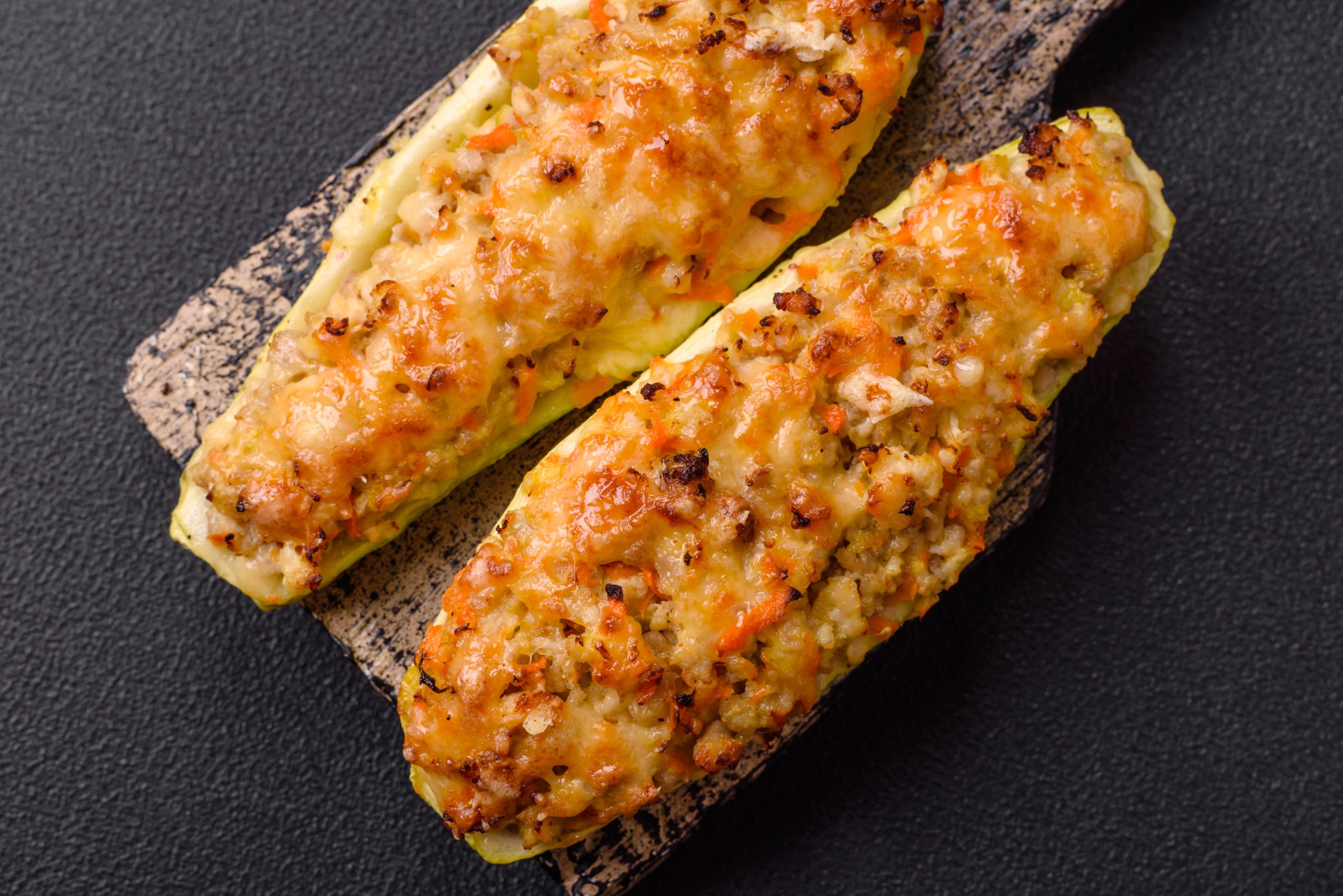 Zucchini halves baked with cheese, tomatoes, meat or meat substitute